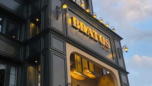 Um hotel com uma placa grande que diz "BRATUS HOTEL".
