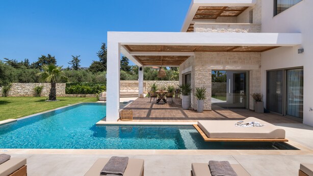 Een modern huis met een zwembad, terras en een pergola.