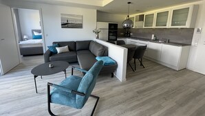 A modern apartment with a living area, dining space, and kitchen. - Vacation apartment Sunrise 10 with balcony and sea view, Cuxhaven Duhner Allee (Cuxhaven)