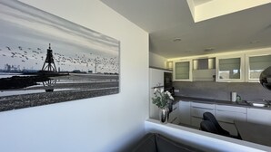 A modern kitchen with white cabinets, a built-in oven, and a stainless steel sink. - Vacation apartment Sunrise 10 with balcony and sea view, Cuxhaven Duhner Allee (Cuxhaven)