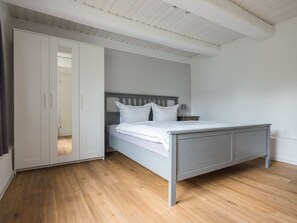 A bedroom with a bed, a wardrobe, and a nightstand. - Two bungalows with their own jetty 5 minutes from the lake (Rheinsberg)