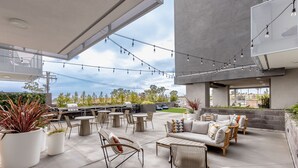 Un patio al aire libre con asientos, luces colgantes y plantas en macetas.