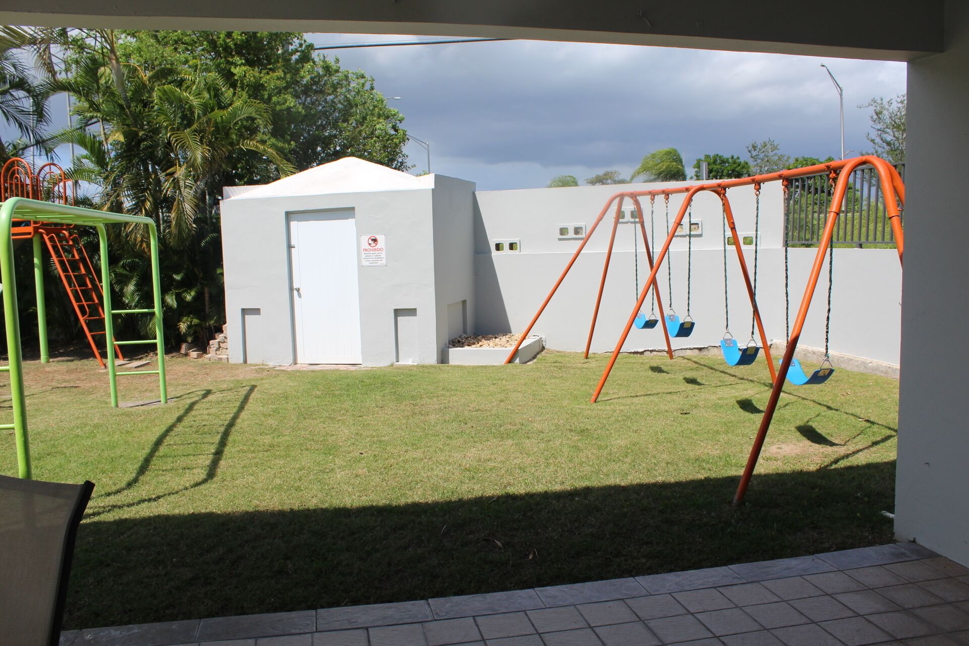 Un parque infantil con columpios y una estructura para escalar.