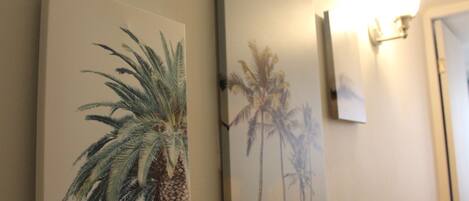 Two wall-mounted paintings of palm trees.