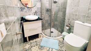 Une salle de bain avec une douche, un lavabo et des toilettes.