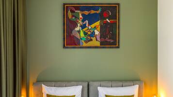 Una habitación de hotel con una cama, dos lámparas de noche y un cuadro en la pared.