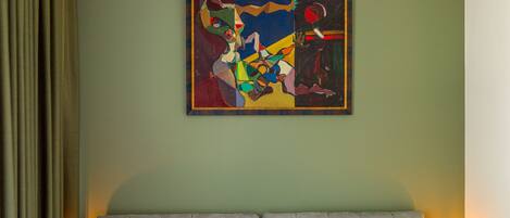 Una habitación de hotel con una cama, dos lámparas de noche y un cuadro en la pared.