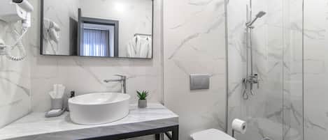 A modern bathroom with a marble sink, a large mirror, a hairdryer, a shower, and a toilet.