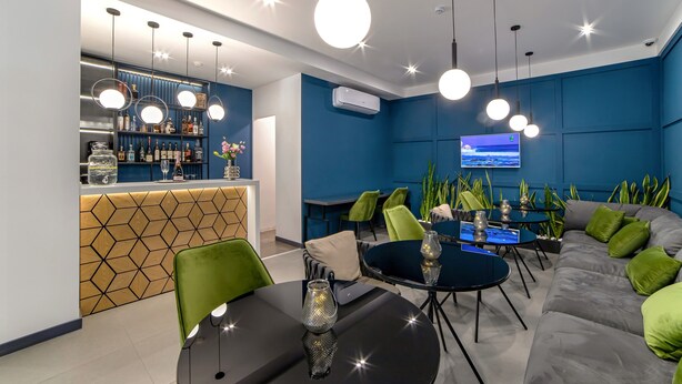 Ein moderner Loungebereich mit Bar, Sitzgelegenheiten und einem Fernseher.