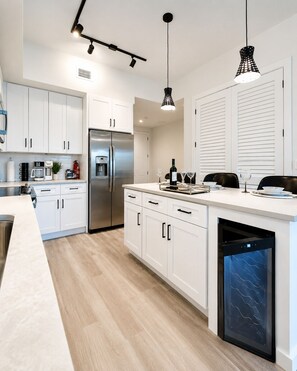 A modern kitchen with white cabinets, stainless steel appliances, and a dishwasher.