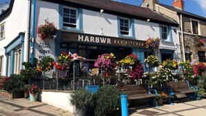 Een traditionele pub genaamd 'Harbwr Bar Kitchen' met terras en bloemdecoraties.