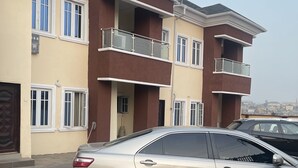 Un edificio residencial de dos pisos con un balcón en el segundo piso.