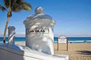 A beach scene with a white structure labeled 'LAS OLAS' and a palm tree.