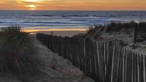 A beach with a wooden fence and vegetation. - La maisonnette du Golf (Lacanau)