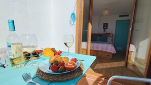 Ein Esstisch mit einem Teller Essen, einer Flasche und einem Glas Weißwein.