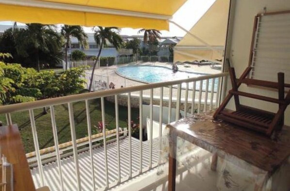 Enjoy a refreshing view of the pool area from this balcony.