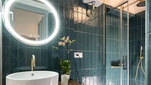 Een badkamer met een wit wastafel, een ronde spiegel, een toilet en een douchehoek.