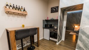 A compact kitchen with a wooden countertop, a built-in microwave, and a small refrigerator.