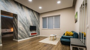 A modern living room with a fireplace, a blue sofa, and a television.