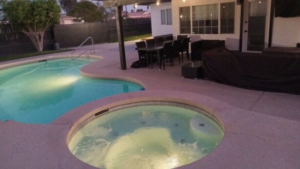 A backyard with a swimming pool, a hot tub, and outdoor furniture. - Located in the heart of Palm Desert (Palm Desert)