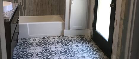 A bathroom with a bathtub, a toilet, and a shower area.