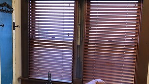 A room with a brown leather chair, a small wooden table with a metal sculpture, and two windows with wooden blinds. - Downtown Secluded & Peaceful Armory Park 10 min walk to Club Congress (Tucson)