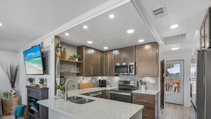 Una cucina moderna con una grande isola, elettrodomestici in acciaio inossidabile e pensili in legno.