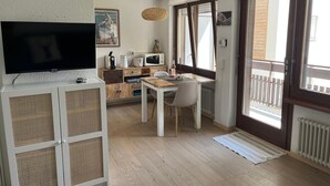 A compact living space with a kitchenette, a dining area, and a television. - Central Zermatt studio for 2 with Matterhorn view, near lifts & restaurants (Zermatt)