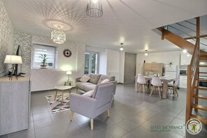 Relax in a stylish living space with a sofa set, dining area, and modern kitchen.