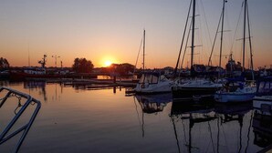 Ein Yachthafen mit vor Anker liegenden Booten bei Sonnenuntergang.