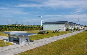A leisure area with a ping pong table, picnic tables, and wind turbines in the background.