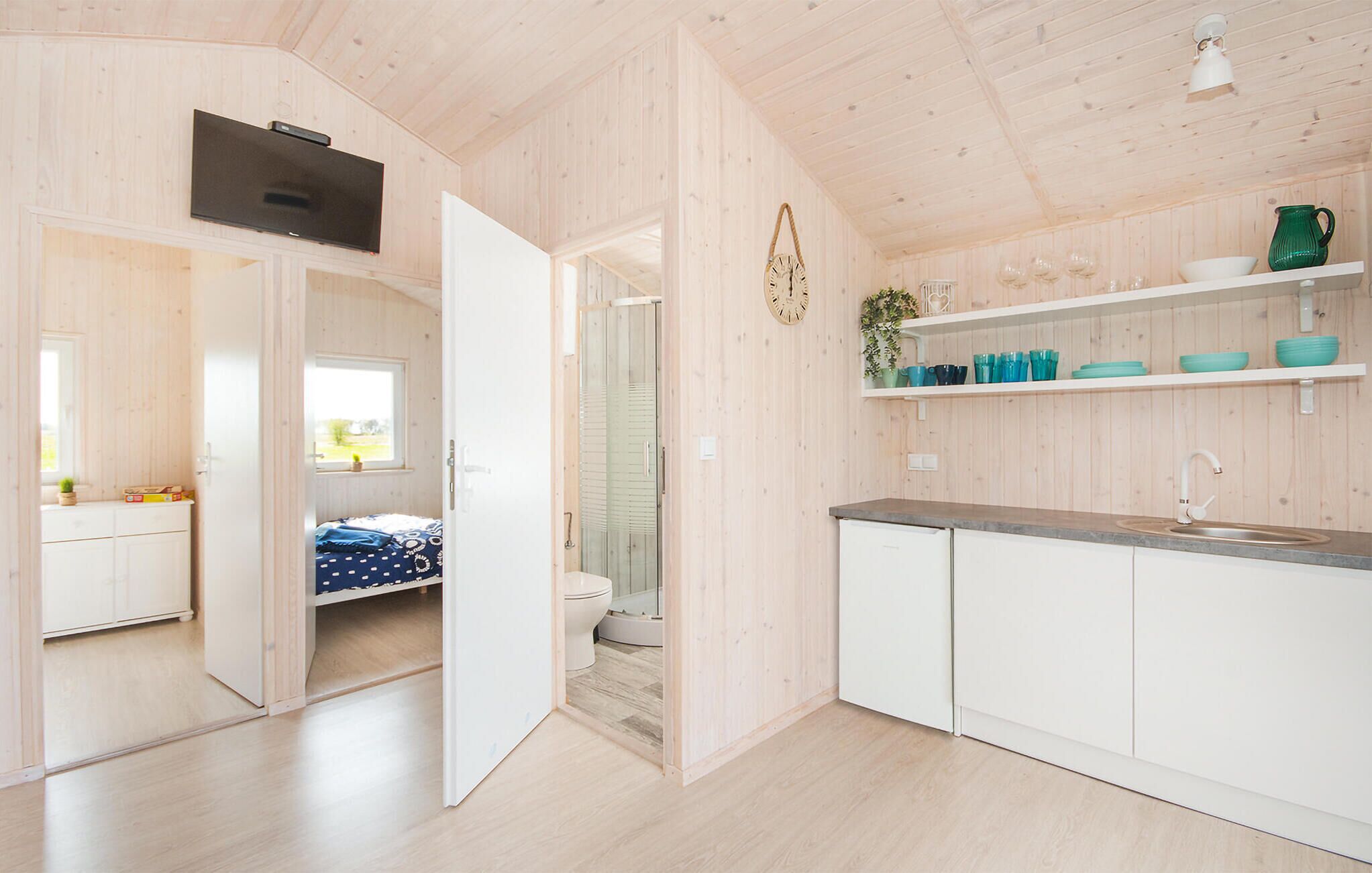 Een moderne, open woonruimte met een keuken, een eethoek en een badkamer.