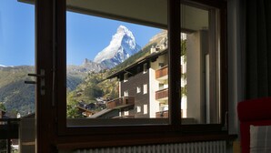 Une chambre avec une fenêtre donnant sur une montagne.