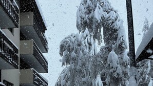 Un chemin enneigé menant à un bâtiment doté de nombreux balcons.