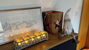 Un comptoir en bois orné d’une carte encadrée, d’une statuette de gnome et d’un chandelier avec des bougies allumées.