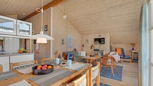 A cozy cabin interior with a dining area, kitchen, and living space.