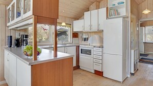 A modern kitchen with white cabinets, a built-in oven, and a refrigerator.