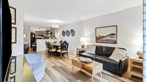 A modern living room with a sofa, coffee table, and dining area. - Walk to beach, updated 2/2 condo sleeps 6, in & outdoor pools, tennis, courtyard (Hilton Head Island)