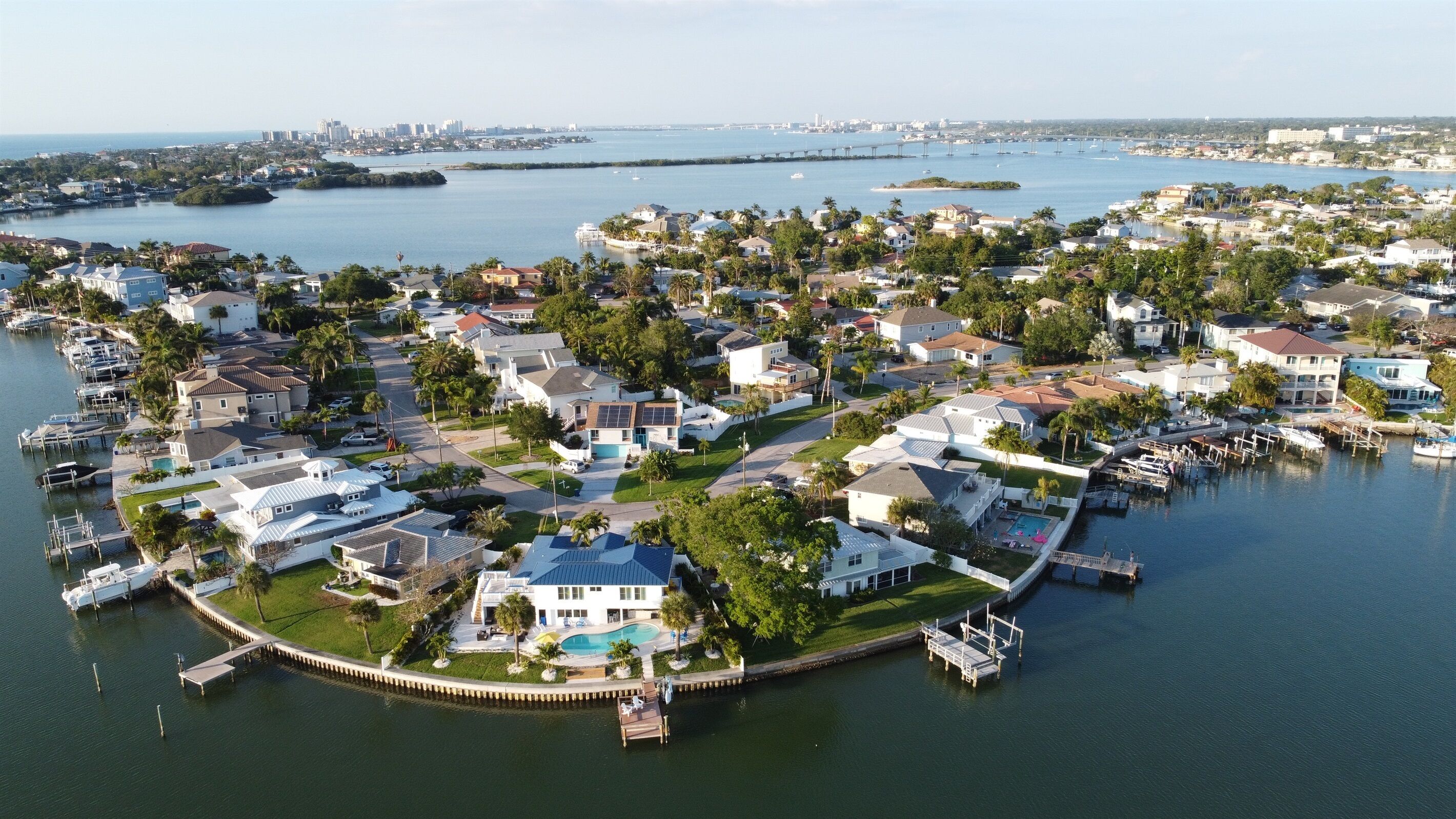 Vista aérea de una zona residencial con casas, un puerto deportivo y una extensa masa de agua.