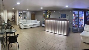 A modern hotel lobby with a reception desk, seating area, and a refrigerator stocked with beverages. - Hotel Dorado san luis (San Luis)