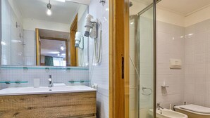 A modern bathroom with a wooden vanity, a glass shower enclosure, and a dual toilet setup. - Residence Cervinia ID 522 (Valtournenche)
