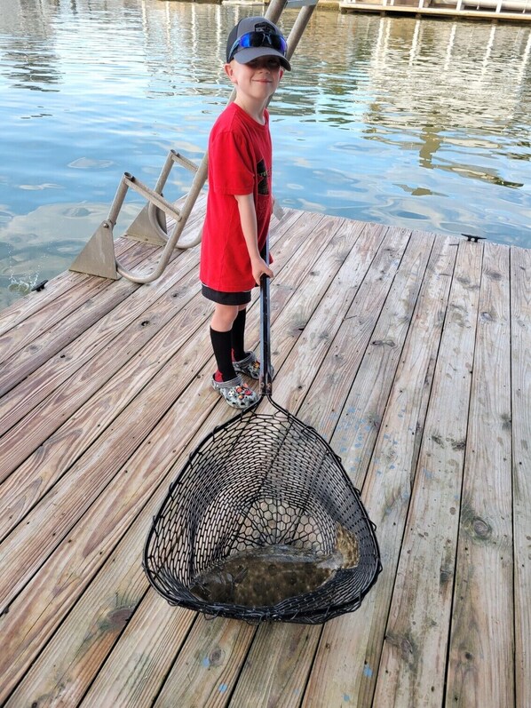 Une jetée en bois avec un filet contenant un poisson.