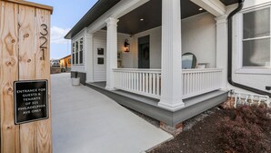 En vit byggnad med en veranda, kolonner och en skylt som visar var gäster och hyresgäster till adressen 321 Philadelphia Avenue kan gå in.