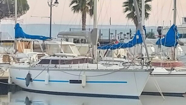 A marina with several boats docked, some with blue covers.