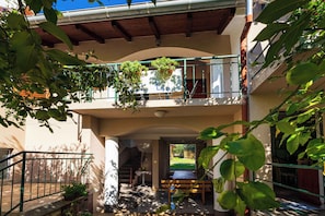 Un edificio de varios niveles con balcones, una escalera y plantas en macetas.