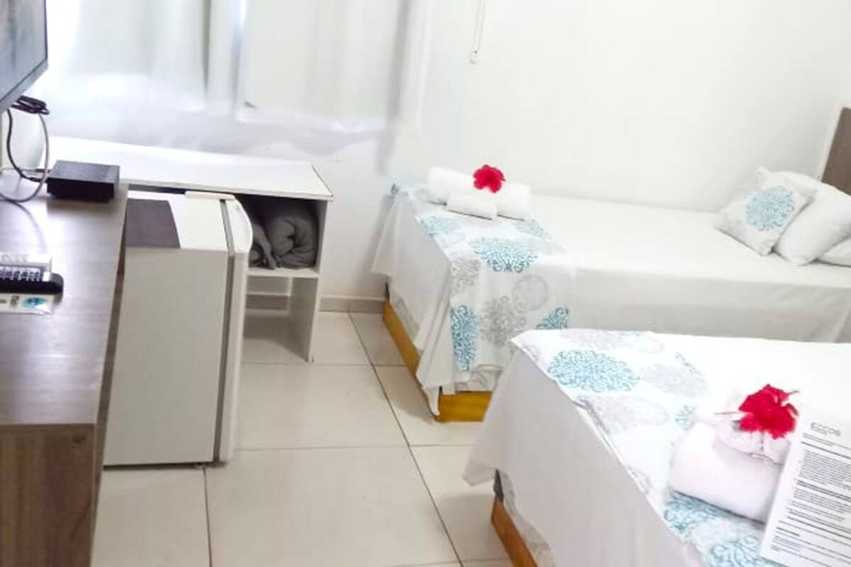 Una habitación de hotel con dos camas, un escritorio y una televisión.