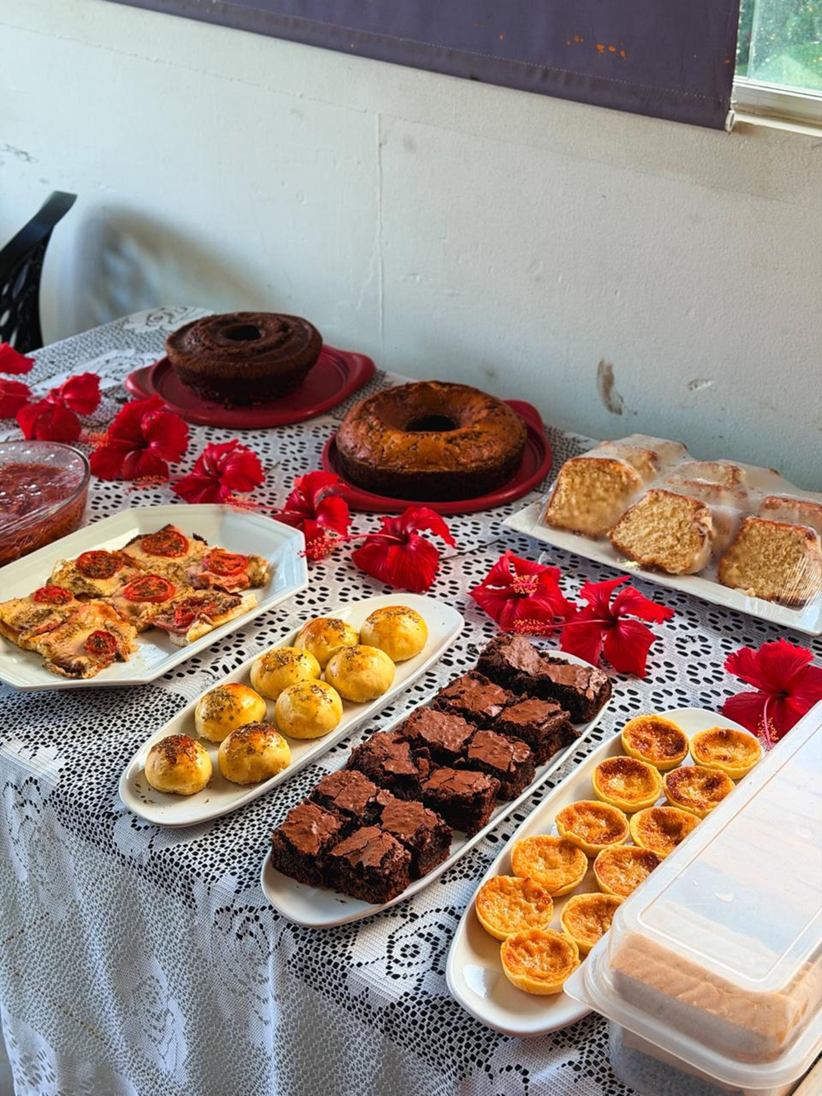 Een tafel met diverse desserts, waaronder een bundt cake, brownies en taartjes.