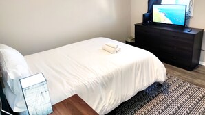 Ein Hotelzimmer mit einem Bett, einem Fernseher auf einer Kommode und einem Fenster mit Vorhängen.