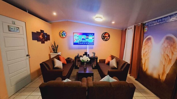 A living room with two sofas, a coffee table, and a flat-screen TV.