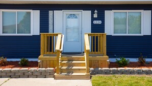 A two-story house with a front porch, a white door, and a mailbox. - Pet-Friendly | Large Group | Hot Tub - All Year (Bay City)